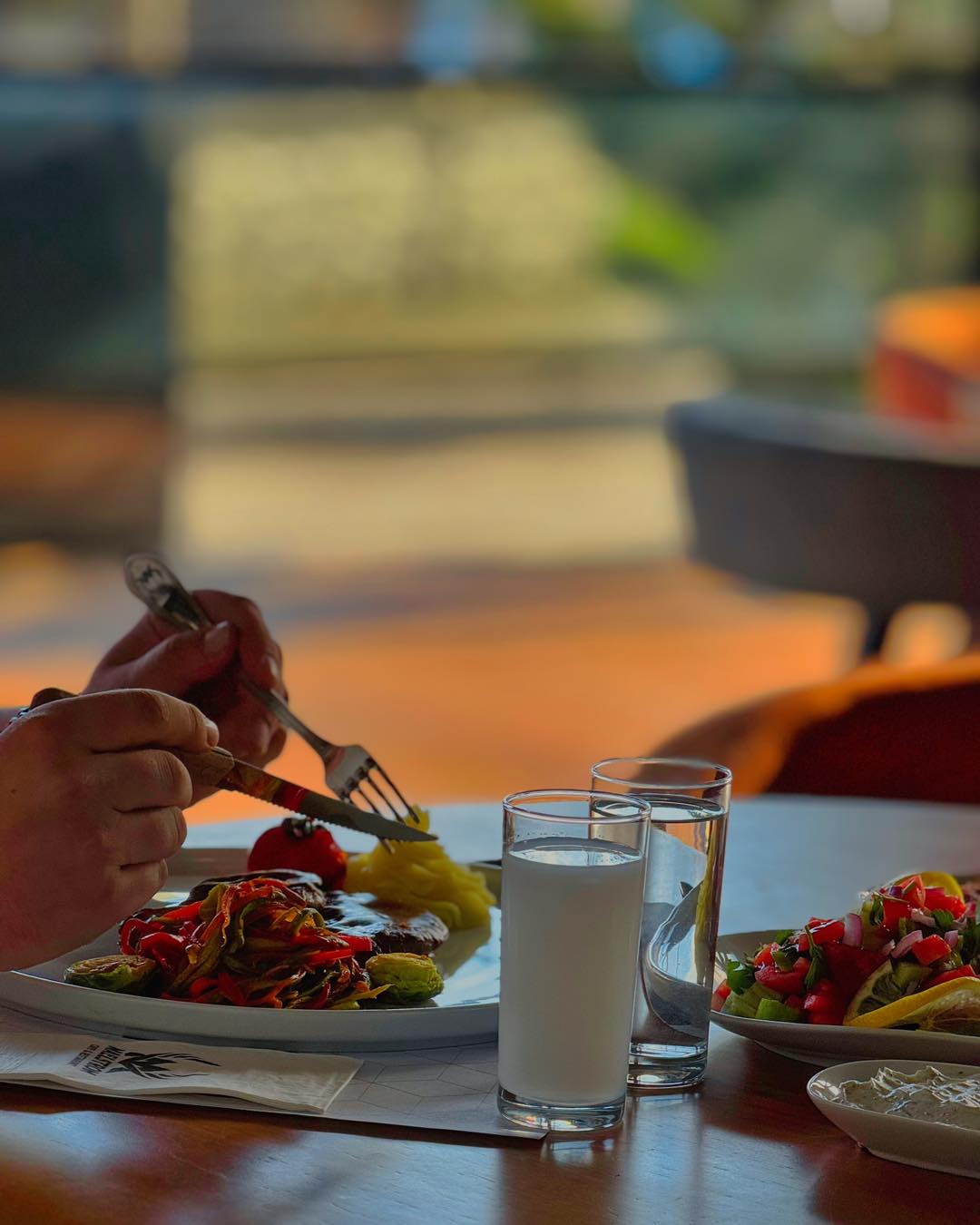 Rakı sofrası — ızgara, mezeler ve gün batımı manzarası